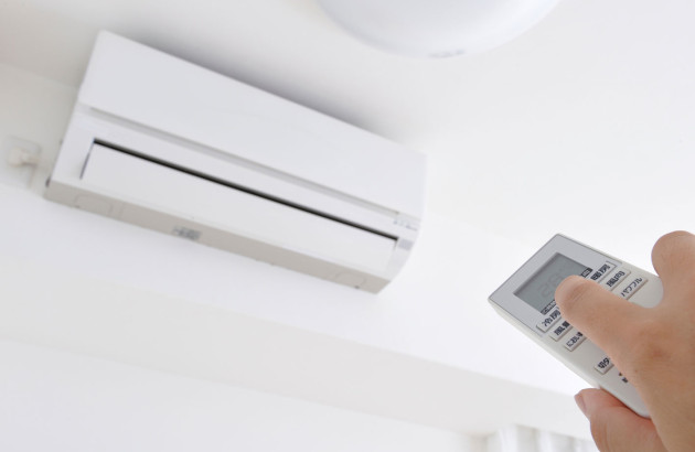 Personne qui utilise une télécommande pour interagir avec sa climatisation