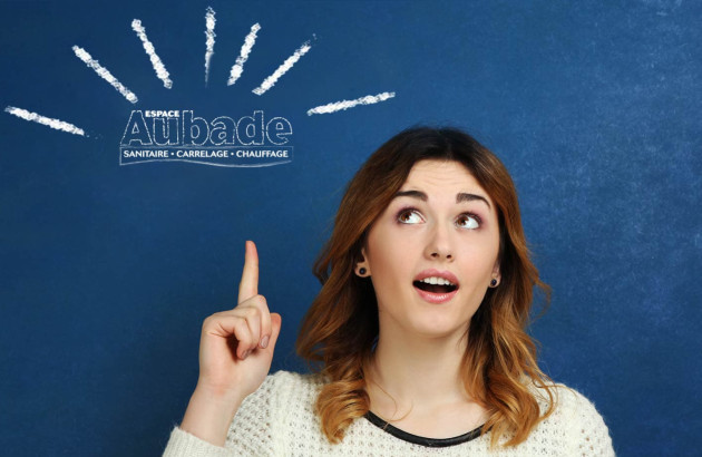 Femme souriante pointant vers le logo Espace Aubade, illustrant l’expertise en carrelage, sanitaire et chauffage pour accompagner les projets de cuisine tendance en 2026.