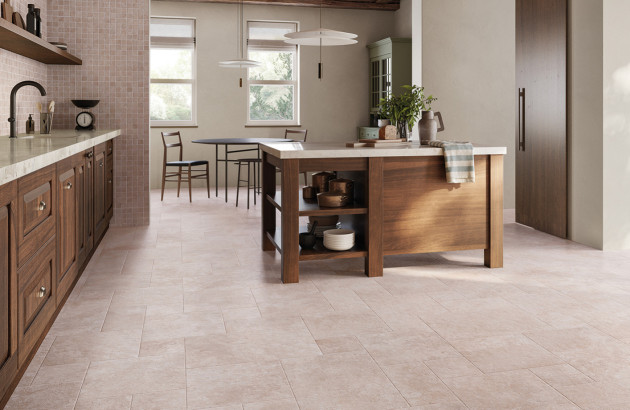 Cuisine chaleureuse avec mobilier en bois foncé et carrelage effet pierre naturelle.