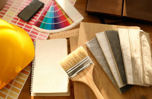 Disposition avec pinceau, carreaux de carrelage, carnet de notes, nuancier, téléphone et casque de chantier