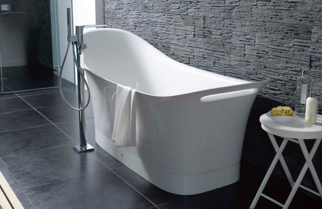 Baignoire ilot avec bac surélevé installée dans une salle de bains proche du mur