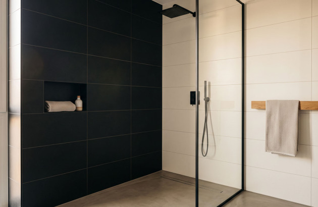 Douche à l'italienne avec un contraste avec  un mur noir pour  un effet de profondeur et un carrelage blanc plus lumineux