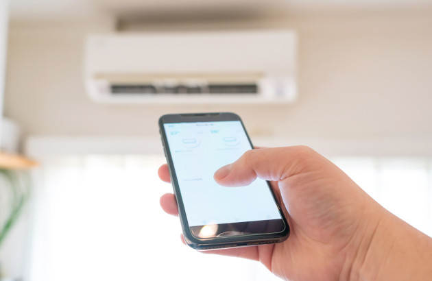 Personne qui contrôle sa climatisation split avec son téléphone