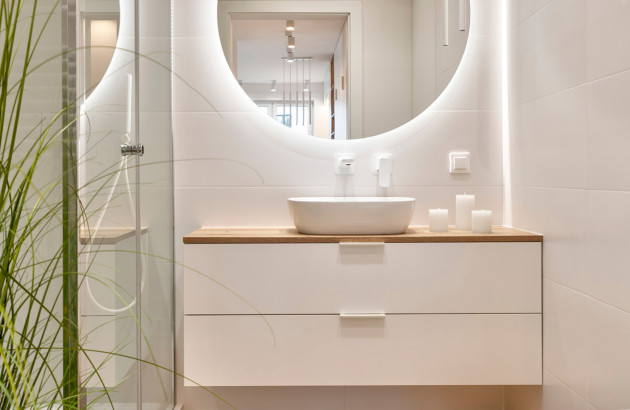 Petite salle de bains avec un miroir rond éclairé à led