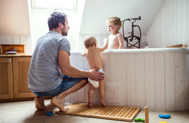 papa entrain de donner le bain aux enfants dans la baignoire