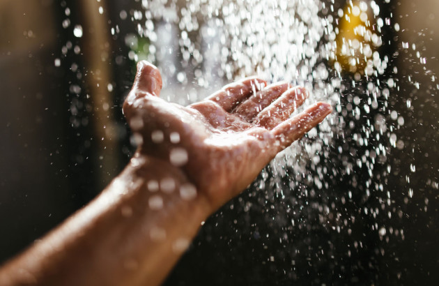 Main qui reçoit de l'eau qui coule de la douche