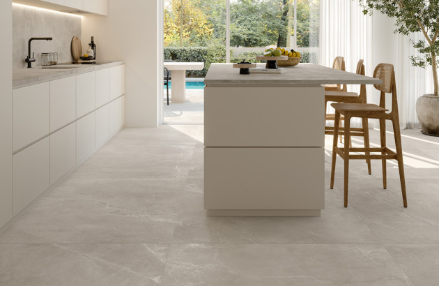 Cuisine lumineuse avec carrelage imitation pierre claire et mobilier aux lignes épurées.