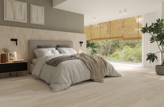 Chambre lumineuse avec carrelage clair effet bois, grande baie vitrée et déco minimaliste.