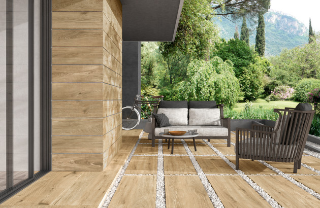 Terrasse extérieure avec dalles effet bois et aménagement paysager moderne.