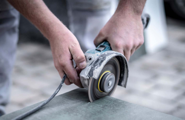personne qui découpe un carreau de carrelage