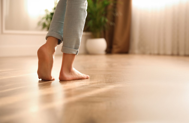Femme qui marche pieds nus sur un plancher chauffant