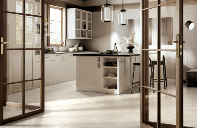 Cuisine familiale élégante avec carrelage beige effet pierre et îlot central fonctionnel.