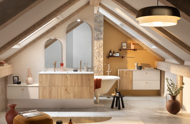 Salle de bains sous combles avec meuble double vasque suspendu en bois et baignoire îlot.