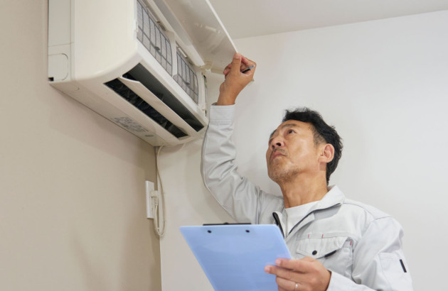 Homme asiatique qui regarde l'intérieur d'une climatiastion