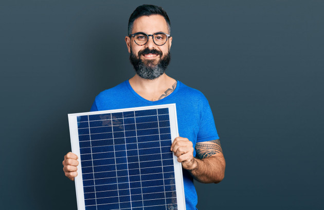 Homme qui tient un panneau solaire
