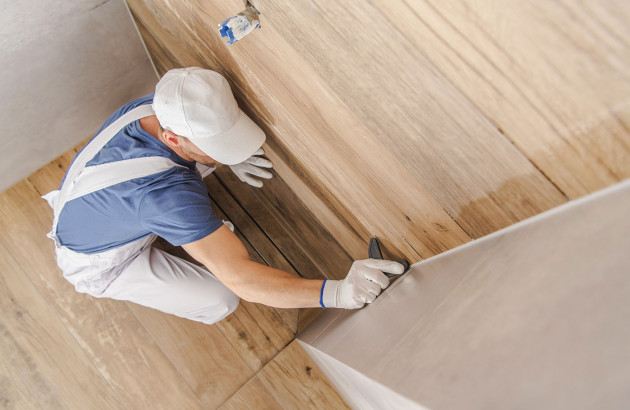 professionnel qui applique le joint d'étanchéité de douche