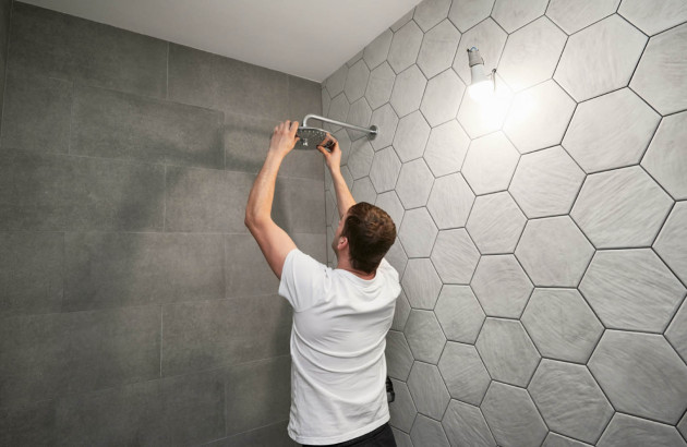 Personne qui installe une douche de tête