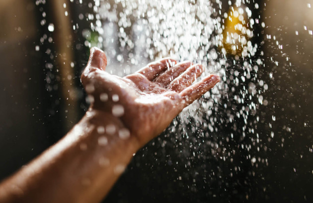 Eau de douche qui coule sur une main