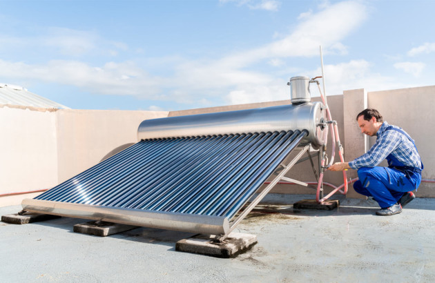 Homme qui installe un panneau solaire thermique