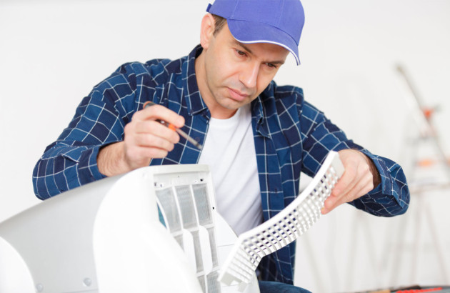Homme qui entretien son climatiseur mobile