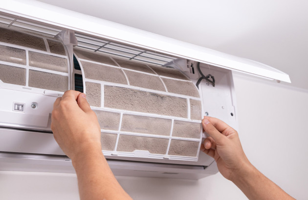 Nettoyage du filtre d’un climatiseur mural lors d’un entretien domestique.