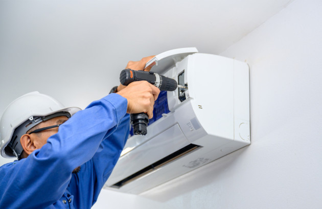 Technicien installant une climatisation murale