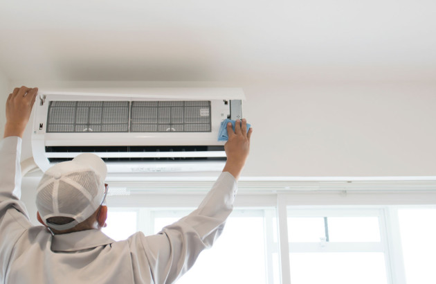 Homme qui installe une unité de climatisation