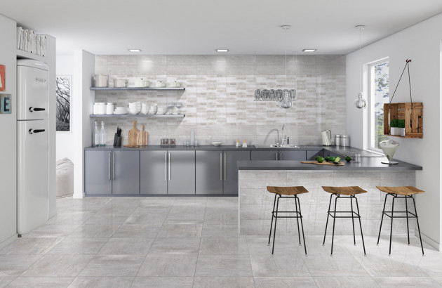 Cuisine contemporaine avec carrelage gris clair brillant et espace repas intégré.