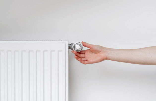 Personne qui règle le thermostat d'un radiateur