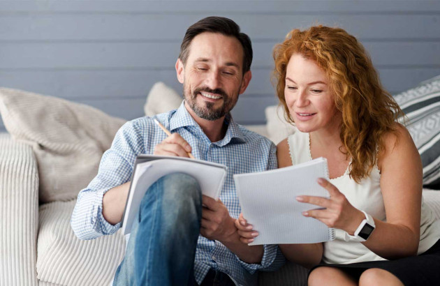 Couple qui prend des notes sur des feuilles de papier
