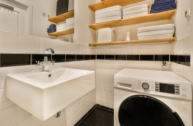 Minuscule salle de bains avec un lavabo et une machine à laver