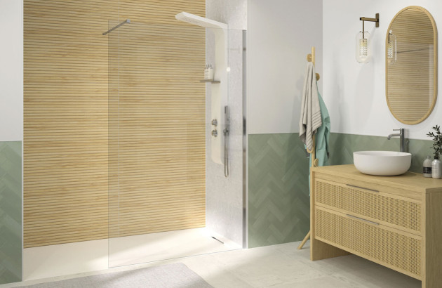 salle de bain moderne avec une paroi de douche en verre près d'un mur d'accent en lattes de bois clair avec un carrelage vert menthe à motif chevrons