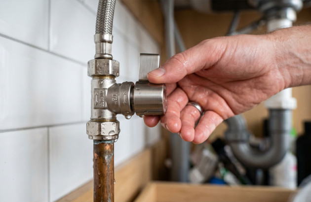 Fermeture d’une vanne d’arrivée d’eau avant le démontage du meuble vasque.