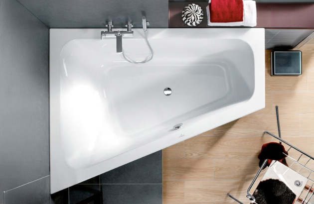 Baignoire asymétrique gain de place installée dans une petite salle de bains moderne.