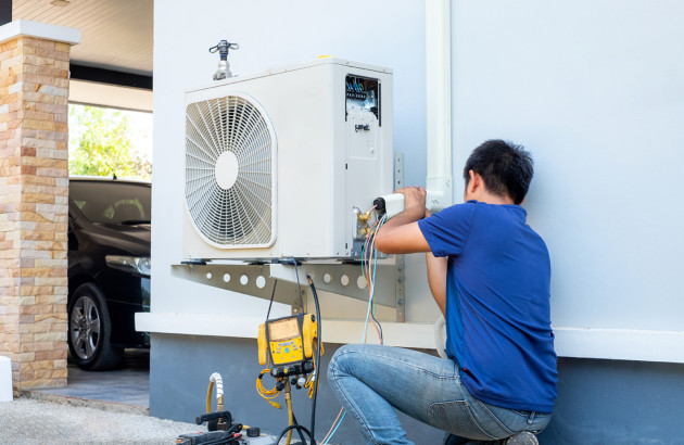 Installation d’une unité extérieure de climatisation par un technicien professionnel.