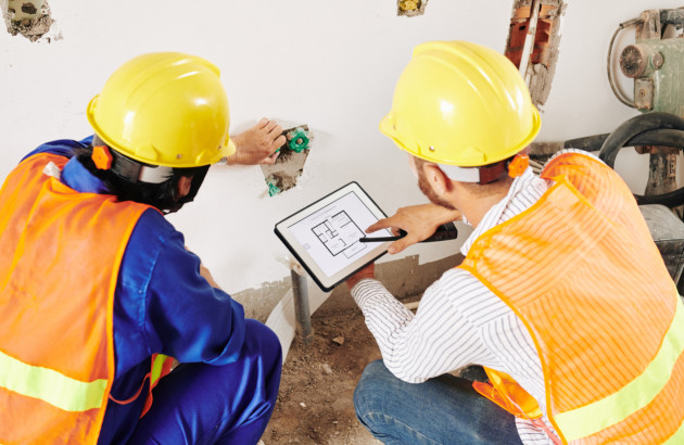 Artisans en rénovation de salle de bains, préparation pour remplacer une baignoire par une douche sécurisée.