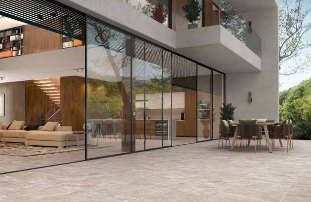 Terrasse contemporaine avec carrelage extérieur gris et grandes baies vitrées panoramiques.