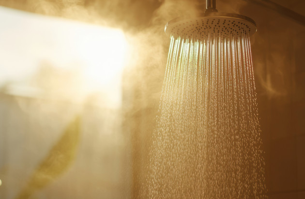 Pommeau de douche qui projette de l'eau chaude, de la vapeur s'échappe du jet