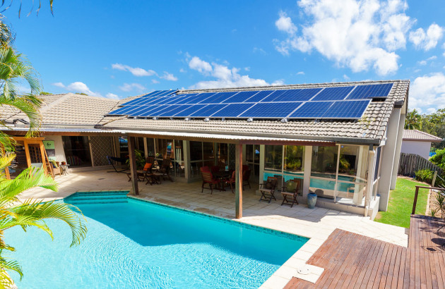 Installation solaire photovoltaïque sur le toit d’une maison avec piscine.