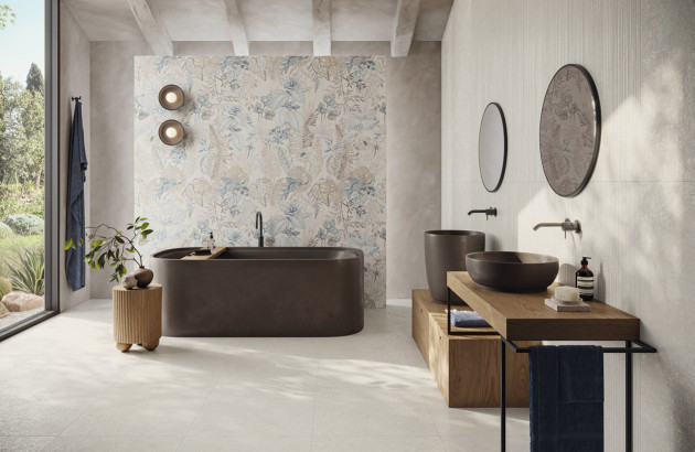 Salle de bains contemporaine avec baignoire noire et faïence florale murale.