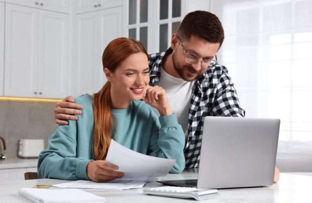 Couple qui regarde un écran d'ordinateur et traite des documents