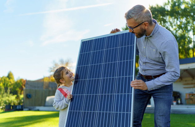 Famille qui tient un panneau solaire