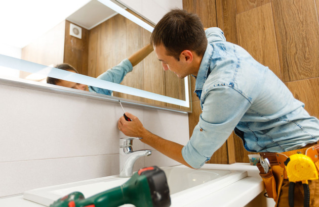 Conseiller expert qui fixe un miroir au mur