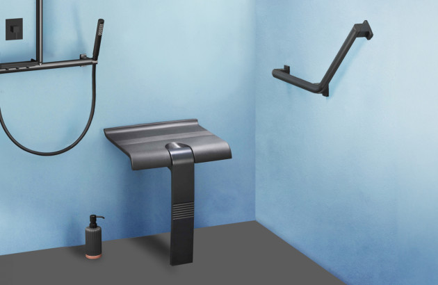 Barre d’appui design noire installée dans une douche moderne aux murs bleus