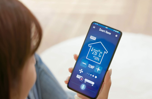 Femme qui utilise son téléphone pour contrôler la ventilation de sa maison