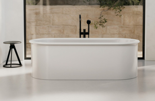 Baignoire îlot ovale aux lignes douces dans un espace épuré et lumineux.