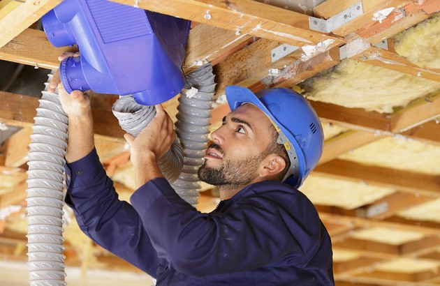 Professionnel effectuant l'installation de la gaine de climatisation