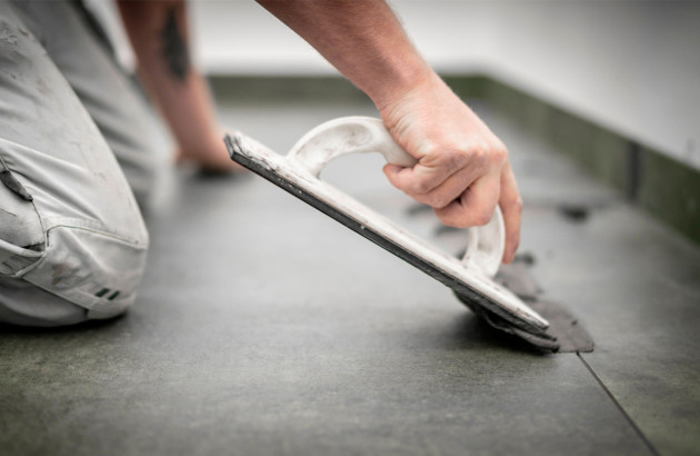 Homme qui utilise une taloche pour faire des joints de carrelage extra-fin
