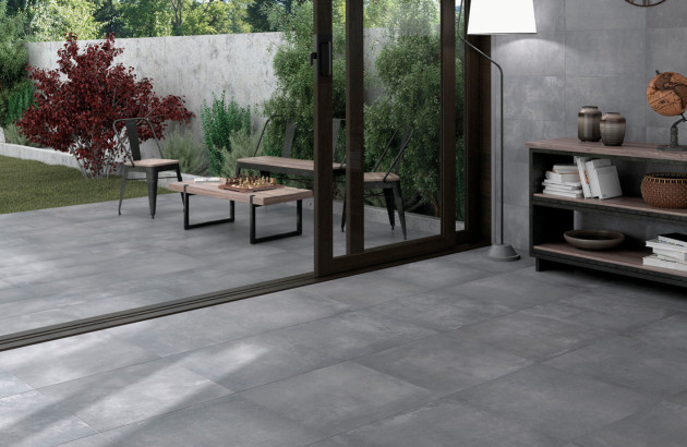 Terrasse et séjour ouverts sur jardin avec grès cérame gris au sol, continuité intérieur/extérieur.