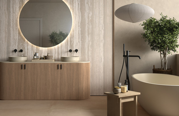 Salle de bains élégante avec meuble texturé, baignoire îlot et carrelage aux tons naturels.